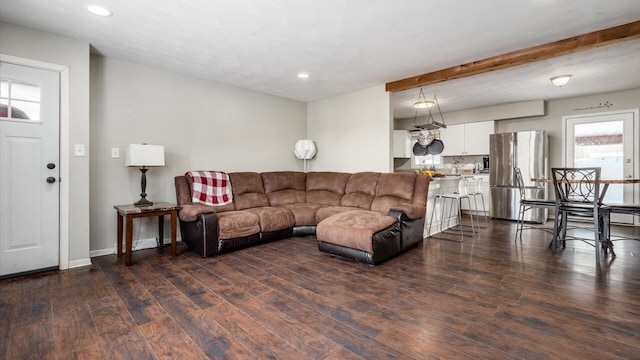 living room featuring beamed ceiling and dark hardwood / wood-style flooring