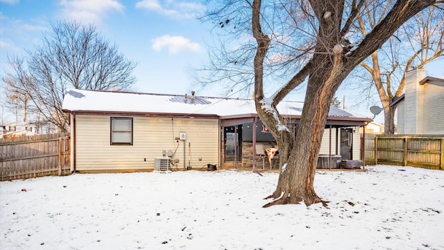 snow covered house featuring cooling unit