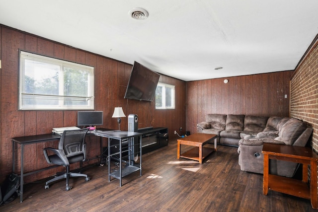 home office with dark hardwood / wood-style flooring and wooden walls