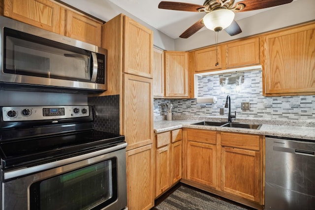 kitchen with ceiling fan, sink, light stone countertops, backsplash, and appliances with stainless steel finishes