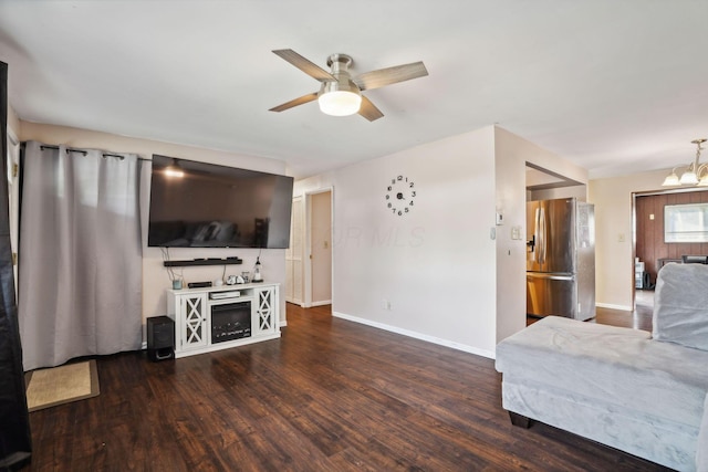 living room featuring dark hardwood / wood-style floors and ceiling fan with notable chandelier