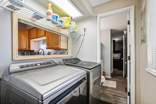 washroom with washing machine and dryer and wood-type flooring