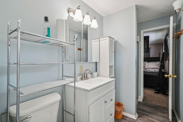 bathroom with hardwood / wood-style flooring, vanity, and toilet