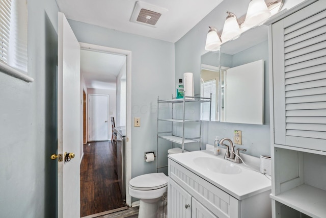 bathroom featuring vanity, hardwood / wood-style flooring, and toilet