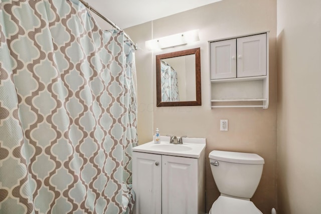 bathroom featuring vanity, toilet, and curtained shower