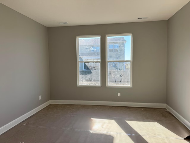 empty room with visible vents, baseboards, and concrete floors