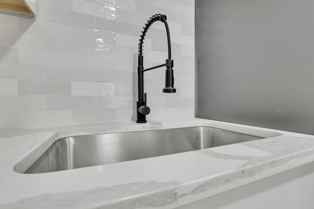 room details featuring light stone countertops and sink