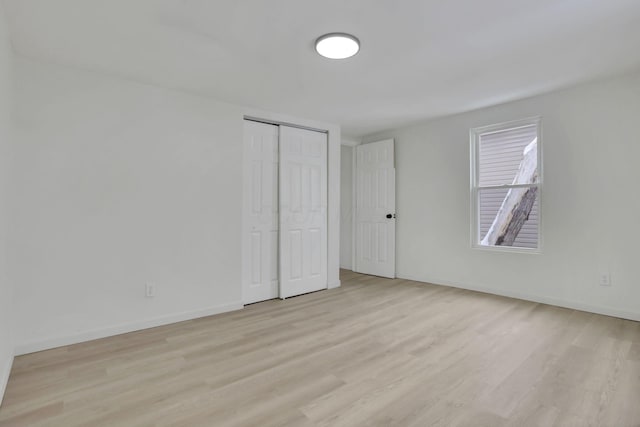 unfurnished bedroom featuring light hardwood / wood-style flooring and a closet