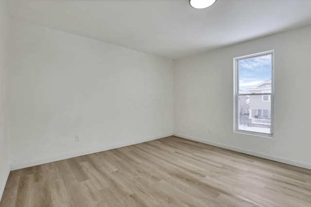 empty room with light hardwood / wood-style flooring and a healthy amount of sunlight