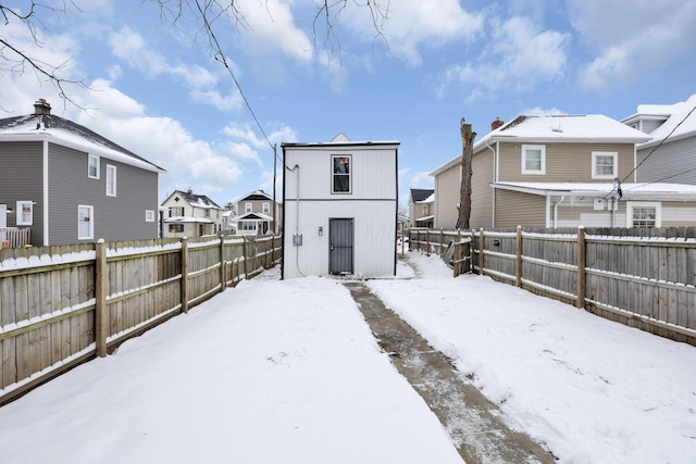 view of snow covered back of property