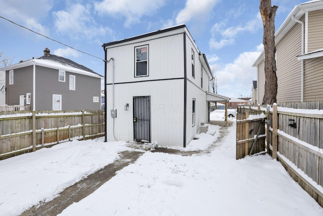 view of snow covered back of property