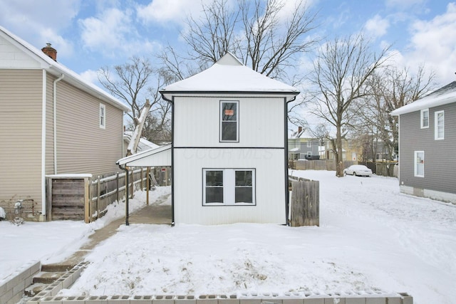 view of snow covered back of property