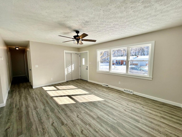 interior space with ceiling fan, wood-type flooring, and a textured ceiling