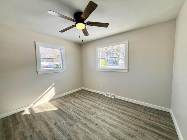 spare room featuring ceiling fan and dark wood-type flooring