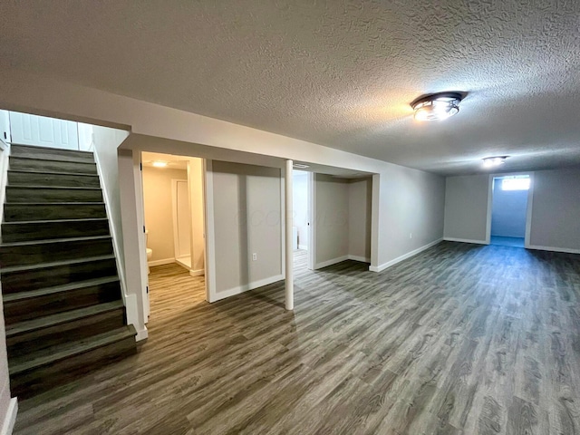 basement with a textured ceiling and dark wood-type flooring