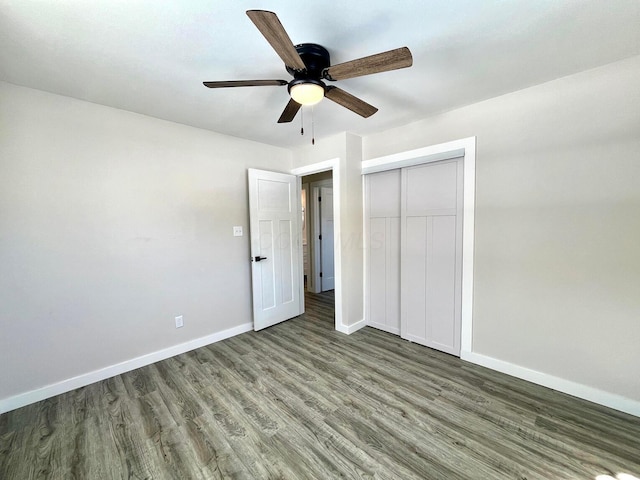 unfurnished bedroom featuring dark hardwood / wood-style flooring, ceiling fan, and a closet