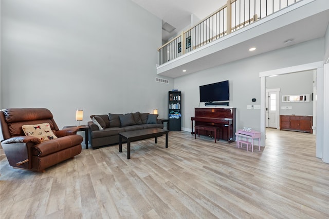 living room featuring a high ceiling and light wood-type flooring