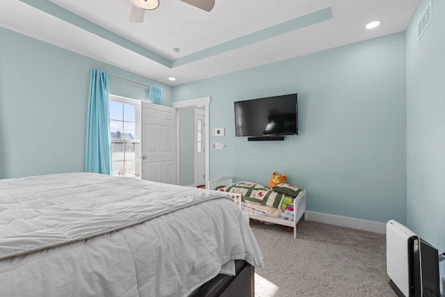 bedroom with a tray ceiling, ceiling fan, and light colored carpet