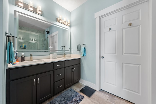 bathroom featuring hardwood / wood-style flooring, vanity, and walk in shower