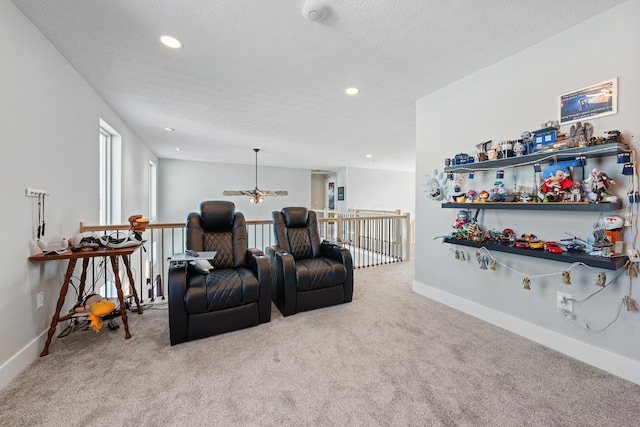 carpeted home theater room with a textured ceiling and ceiling fan