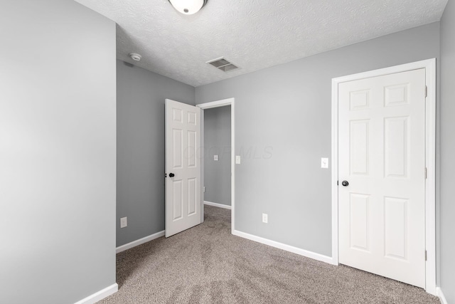 unfurnished bedroom with carpet flooring and a textured ceiling