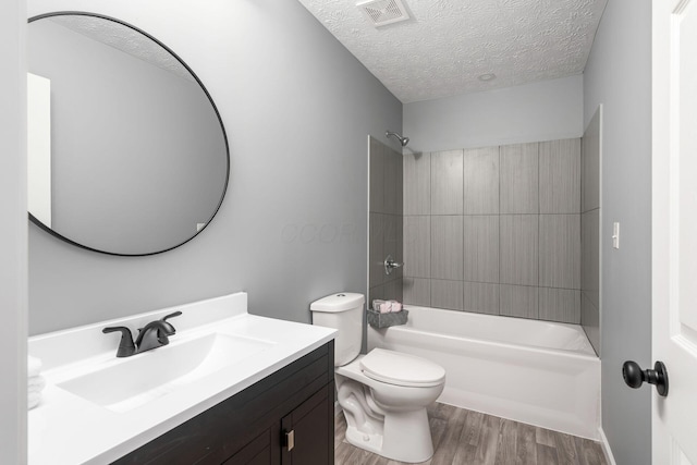 full bathroom featuring vanity, a textured ceiling,  shower combination, wood-type flooring, and toilet