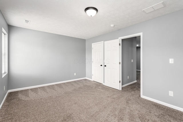 unfurnished bedroom with carpet flooring and a textured ceiling