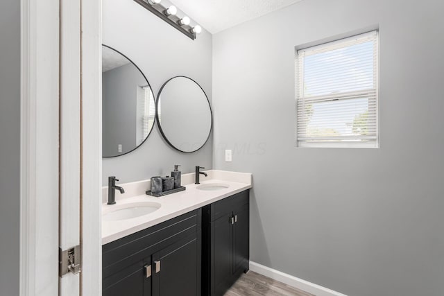 bathroom featuring hardwood / wood-style flooring, vanity, and a textured ceiling