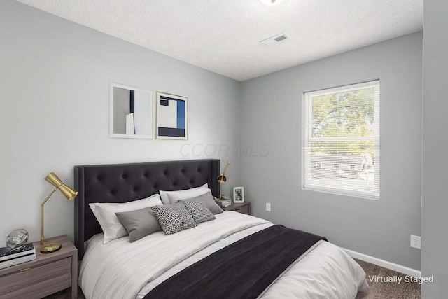 bedroom featuring carpet floors and a textured ceiling