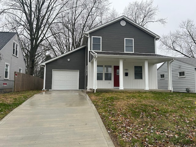 view of front of property featuring covered porch, a garage, and a front lawn