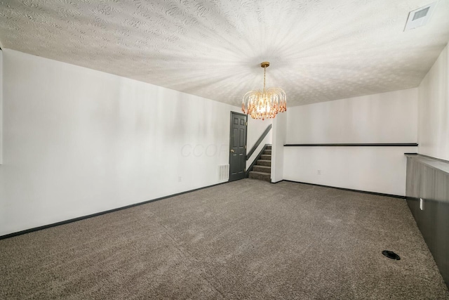 carpeted empty room with a textured ceiling and a chandelier