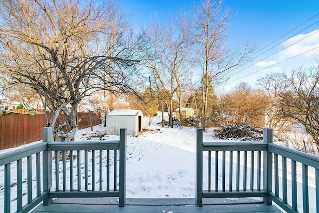 snow covered deck with a shed