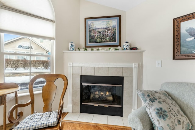 sitting room with lofted ceiling and a fireplace