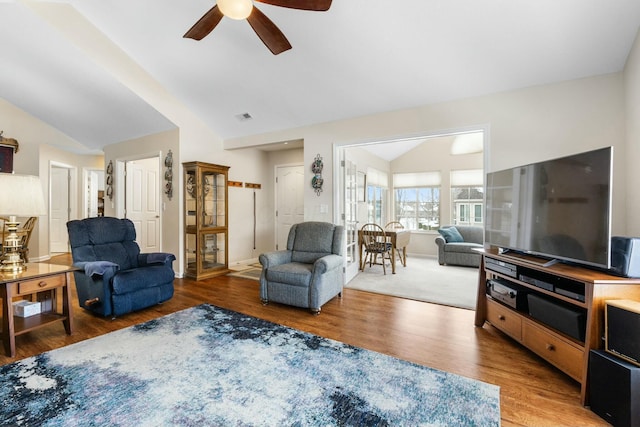 living room with ceiling fan, vaulted ceiling, and wood-type flooring