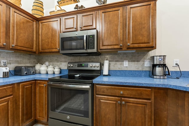 kitchen with appliances with stainless steel finishes and decorative backsplash