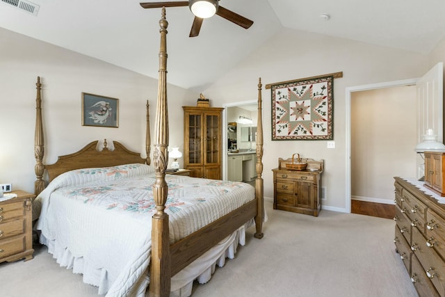 bedroom featuring lofted ceiling, connected bathroom, light carpet, and ceiling fan