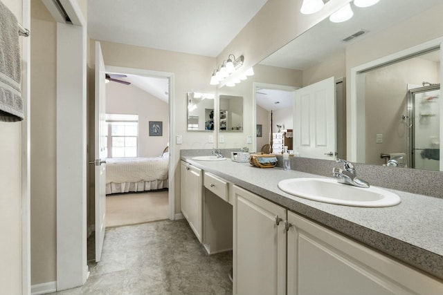 bathroom featuring ceiling fan, vanity, a shower with shower door, and vaulted ceiling