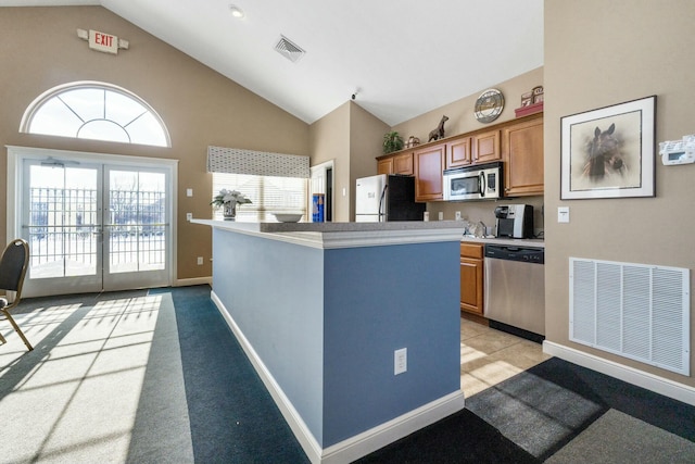 kitchen with a wealth of natural light, high vaulted ceiling, french doors, and appliances with stainless steel finishes