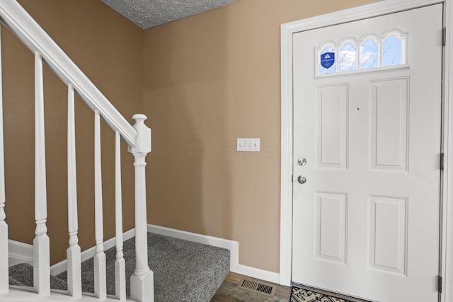 entryway with hardwood / wood-style floors and a textured ceiling