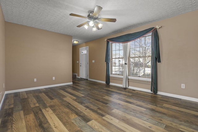 empty room with dark hardwood / wood-style flooring, ceiling fan, and a textured ceiling