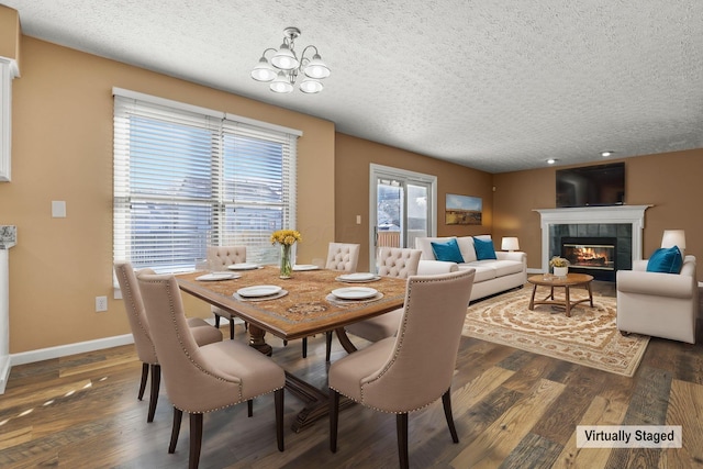 dining space with a chandelier, a fireplace, dark hardwood / wood-style floors, and a textured ceiling