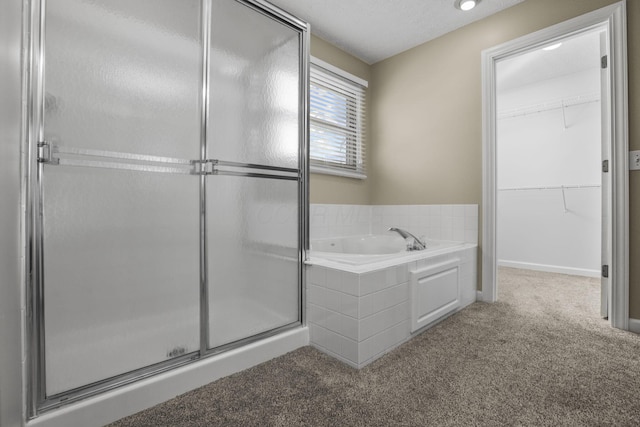 bathroom with shower with separate bathtub and a textured ceiling