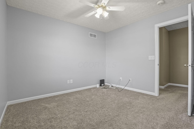 unfurnished room with ceiling fan, carpet flooring, and a textured ceiling