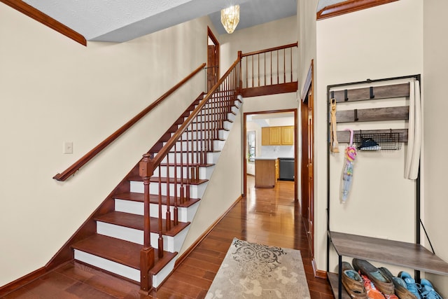 stairs featuring hardwood / wood-style flooring, a textured ceiling, and an inviting chandelier