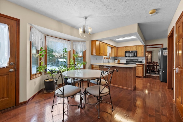 dining area with dark wood-type flooring and a notable chandelier