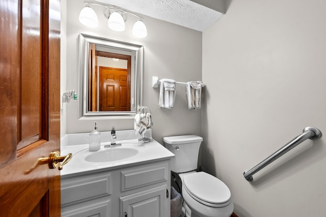 bathroom with vanity, a textured ceiling, and toilet