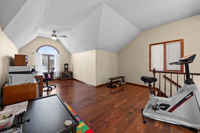 exercise area with a textured ceiling, dark hardwood / wood-style flooring, ceiling fan, and lofted ceiling