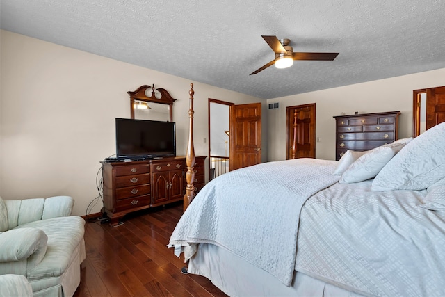 bedroom featuring ceiling fan, dark wood-type flooring, and a textured ceiling