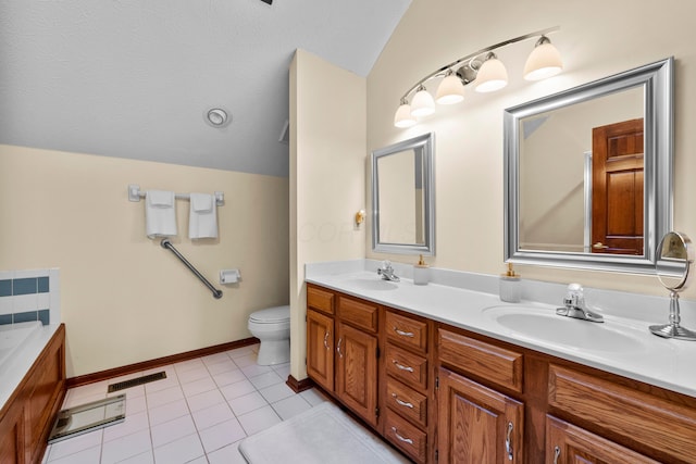 bathroom featuring vanity, a bath, tile patterned floors, vaulted ceiling, and toilet