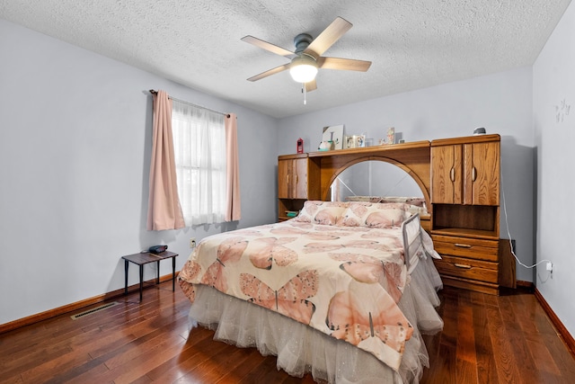 bedroom featuring a textured ceiling, ceiling fan, and dark hardwood / wood-style floors